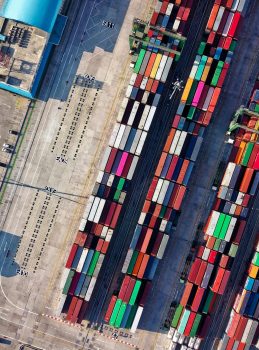 Top view of colorful shipping containers at a bustling port in Jakarta, Indonesia.